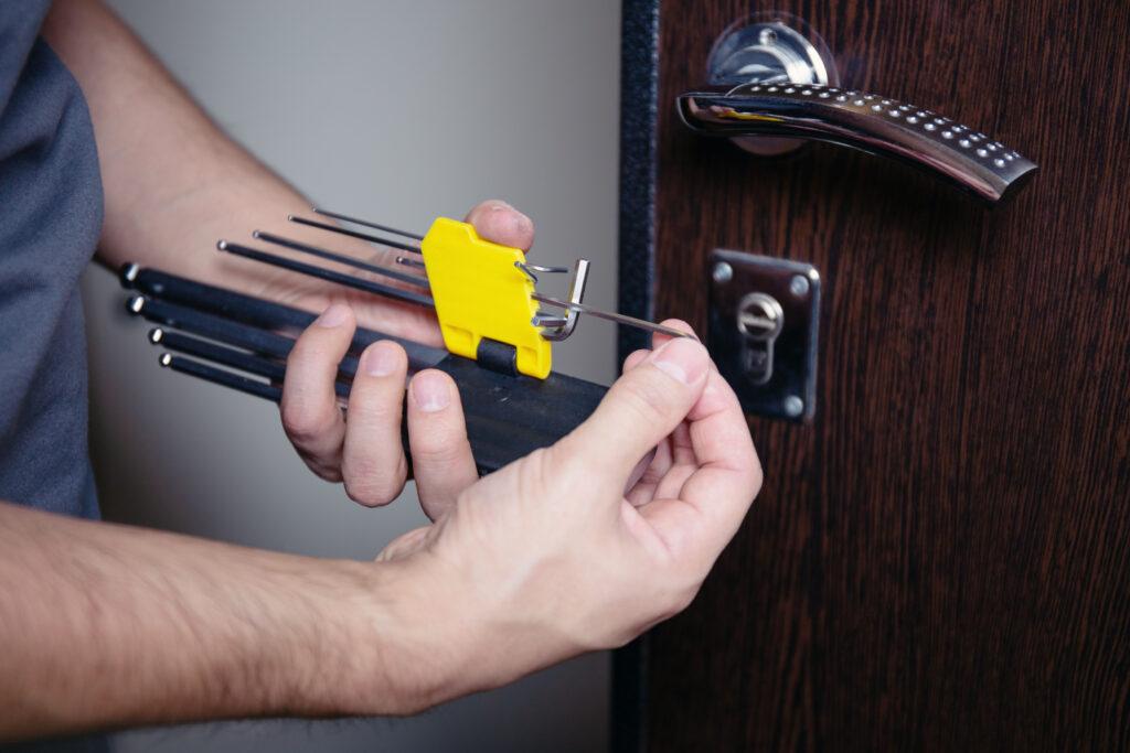 Serrurier réalisant une ouverture fine de porte par crochetage à 