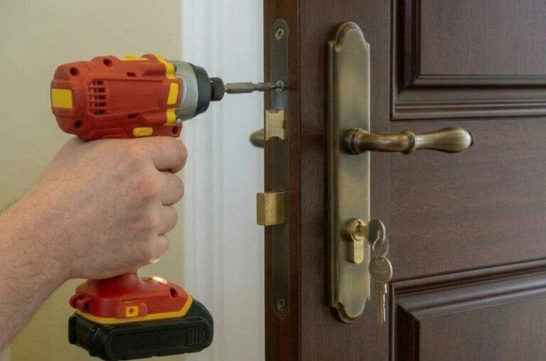 Serrurier remplaçant une serrure en mortaise sur une porte traditionnelle en bois à 